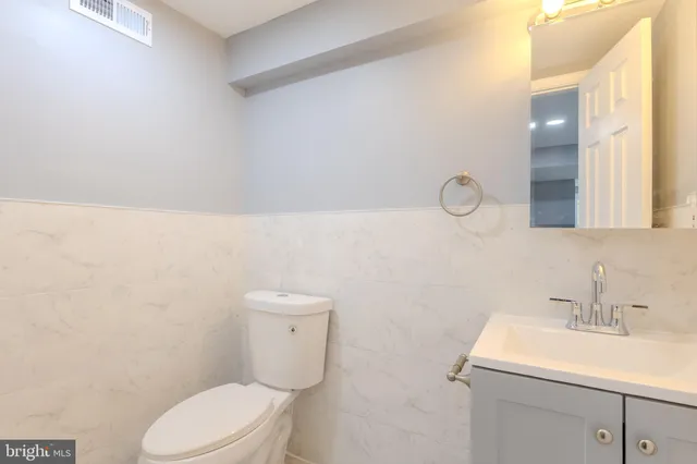 a bathroom with a sink a toilet and a mirror