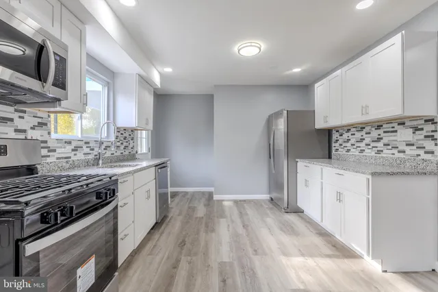 a kitchen with stainless steel appliances granite countertop a stove and a sink
