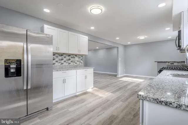a kitchen with granite countertop a refrigerator and a sink