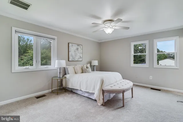 a bedroom with a large bed and a chandelier