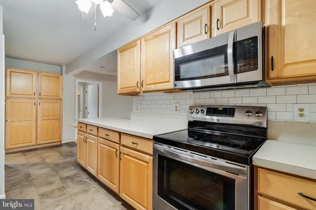 an empty room with windows and chandelier fan