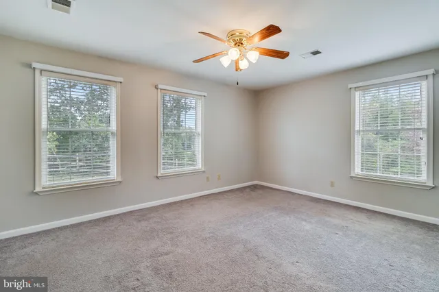 a front view of a house with a garden and trees