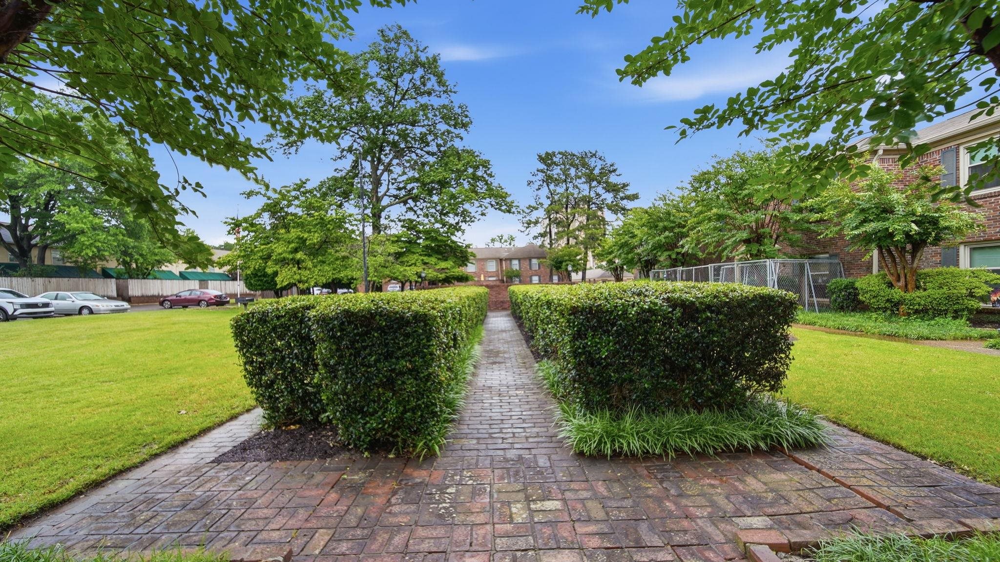 5866 Roxbury Drive, Unit 5866 Memphis, TN 38119 - Photo 20 of 20 Brick paver pathway bordered by manicured hedges, set within a lush green lawn