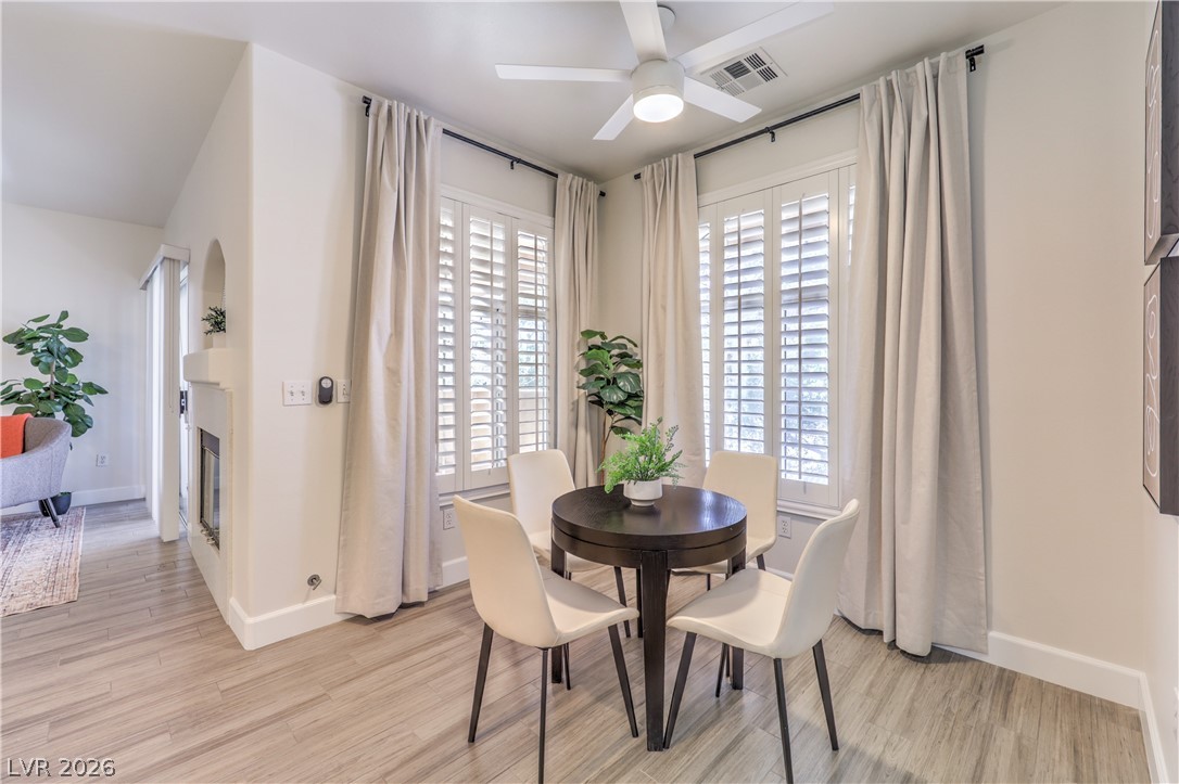 2050 West Warm Springs Road, Unit 1421 Henderson, NV 89014 - Photo 14 of 45 A corner dining space with white plantation shutters and light wood flooring.