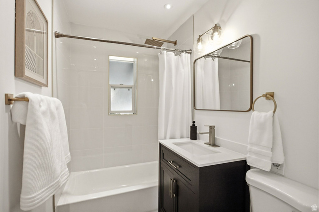1187 East Ridgedale Circle Millcreek, UT 84106 - Photo 14 of 49 Bathroom featuring a white subway tile shower surround, contemporary vanity with white countertop, rectangular mirror with metallic frame, and modern light fixture