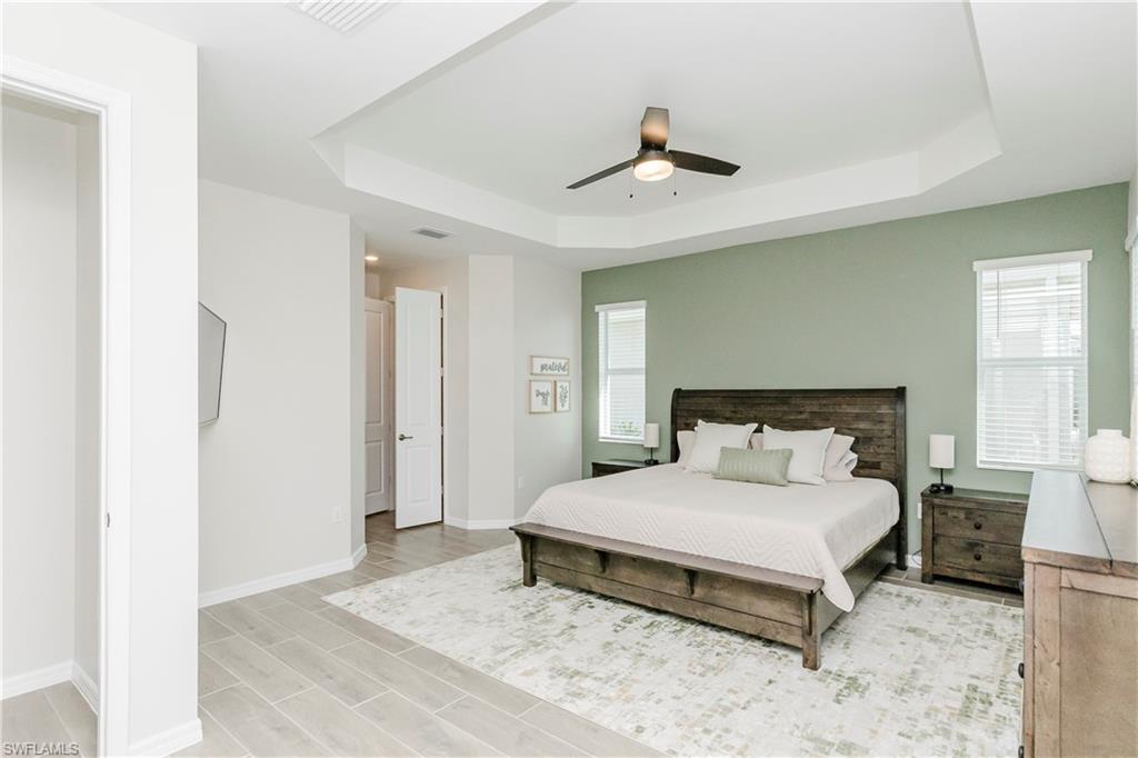 15862 Sugar Hl Drive Babcock Ranch, FL 33982 - Photo 15 of 50 a bedroom with a bed and a chandelier