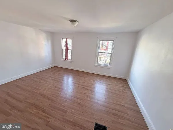 an empty room with wooden floor and window