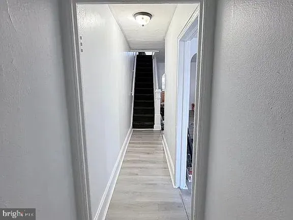 a view of a hallway with wooden staircase