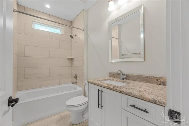 a bathroom with a granite countertop toilet sink and bathtub