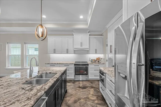 a kitchen with stainless steel appliances granite countertop a sink refrigerator and cabinets
