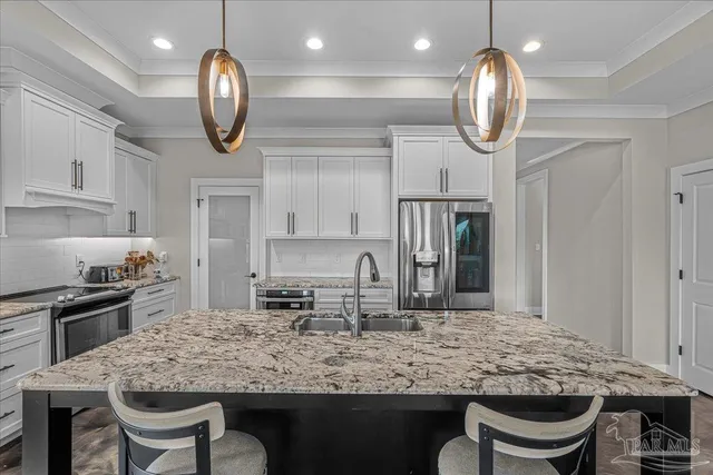 a kitchen with stainless steel appliances granite countertop a stove refrigerator and cabinets