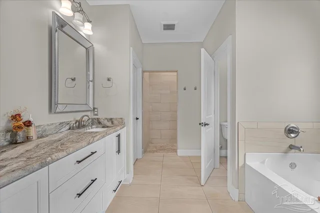 a bathroom with a granite countertop sink mirror and bathtub