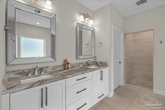 a bathroom with a granite countertop sink double and mirror