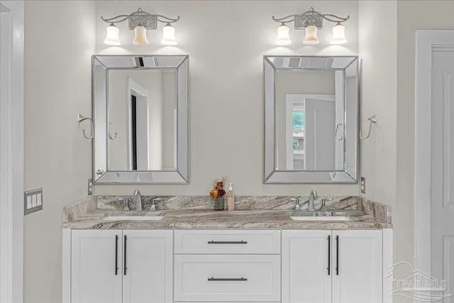 a bathroom with double vanity sinks a vanity and a mirror