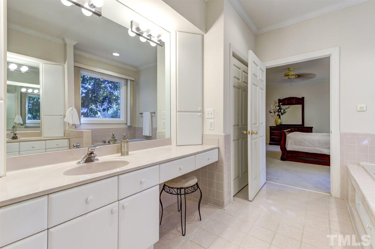 19 Covington Lane Durham, NC 27712 - Photo 15 of 30 a en suite bathroom with a sink a mirror and a shower