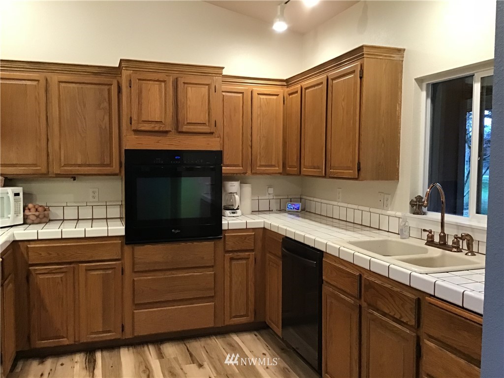 19613 Denmark Street Southwest Rochester, WA 98579 - Photo 22 of 30 a kitchen with stainless steel appliances granite countertop a sink stove and cabinets
