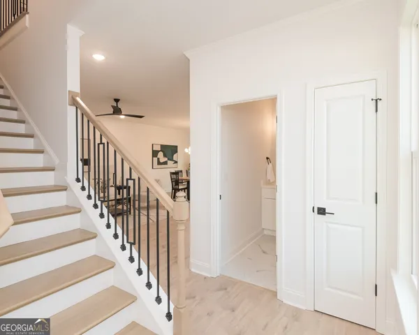 a view of staircase with railing and white walls