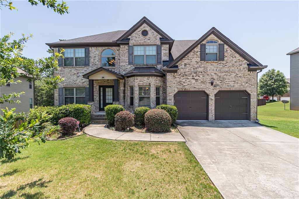 a front view of a house with yard and trees