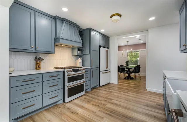 a kitchen with granite countertop a stove cabinets and wooden floor