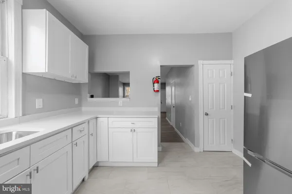 a kitchen with white cabinets and sink