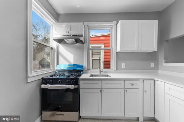 a kitchen with stainless steel appliances white cabinets and a window