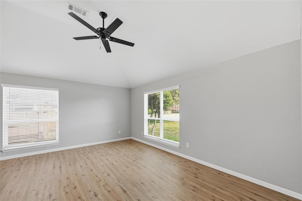 210 South Malone Road Allen, TX 75002 - Photo 4 of 36 an empty room with wooden floor windows and ceiling fan