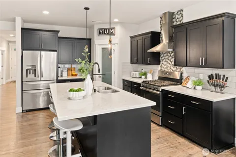 a kitchen with stainless steel appliances kitchen island granite countertop a sink stove and refrigerator