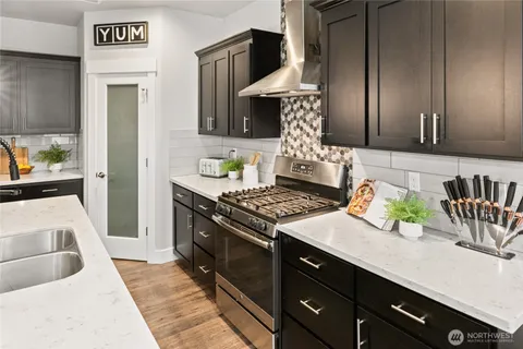 a kitchen with stainless steel appliances granite countertop a stove a sink and a refrigerator