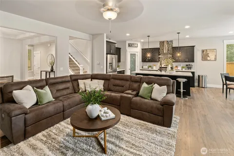 a living room with furniture and a view of kitchen