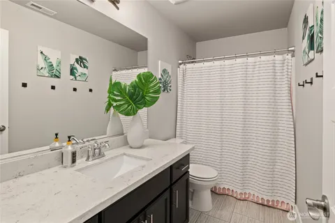 a bathroom with a granite countertop sink a toilet and with mirror