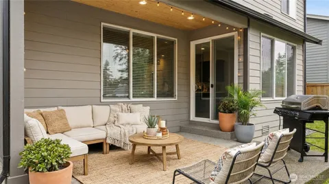 a living room with patio furniture and potted plants