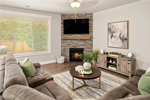 a living room with furniture a flat screen tv and a fireplace