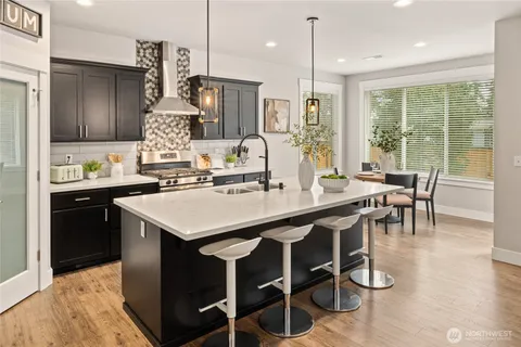a kitchen with kitchen island granite countertop a sink and a refrigerator