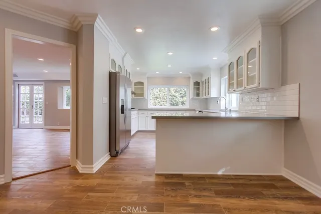 a view of kitchen with stainless steel appliances granite countertop cabinets and wooden floor