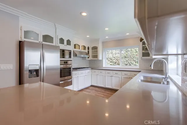 a kitchen with stainless steel appliances a refrigerator and a sink