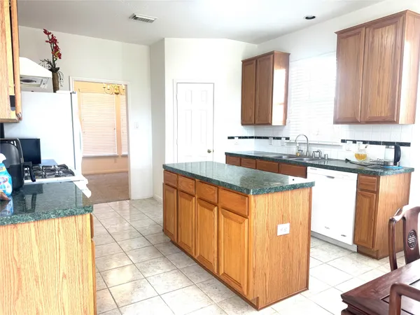 a kitchen with granite countertop a sink and a stove
