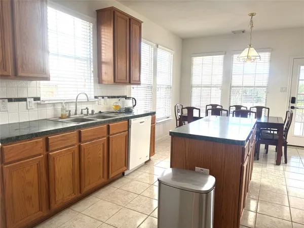 a kitchen with a sink a window and chairs