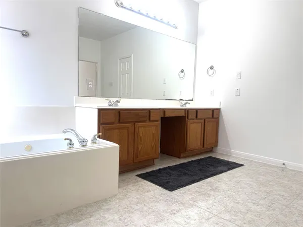 a spacious bathroom with a bathtub sink and mirror
