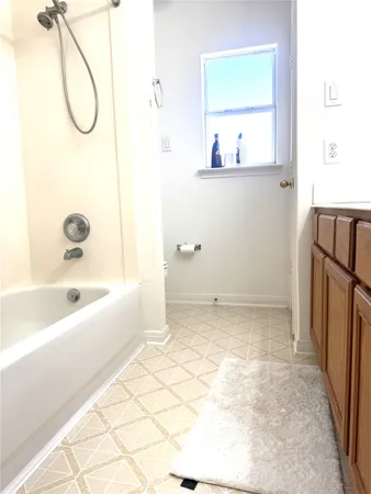 a bathroom with a tub sink and a mirror