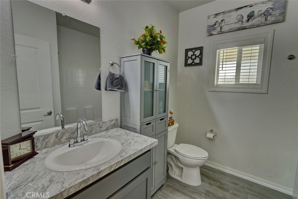 22221 Bloomfield Street, Unit 47 Cypress, CA 90630 - Photo 10 of 30 a bathroom with a granite countertop sink a toilet and mirror