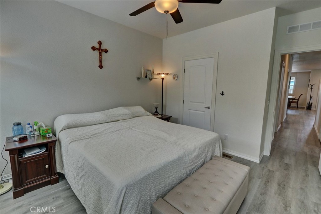 22221 Bloomfield Street, Unit 47 Cypress, CA 90630 - Photo 15 of 30 a bedroom with a bed and a chandelier
