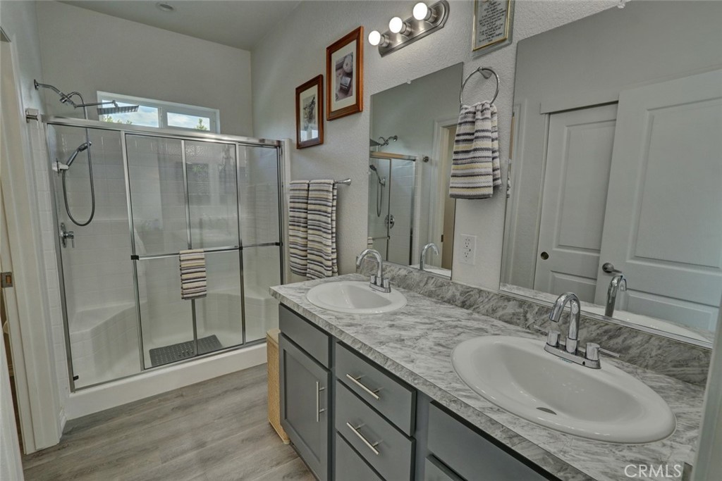 22221 Bloomfield Street, Unit 47 Cypress, CA 90630 - Photo 16 of 30 a bathroom with a granite countertop sink a shower and a mirror