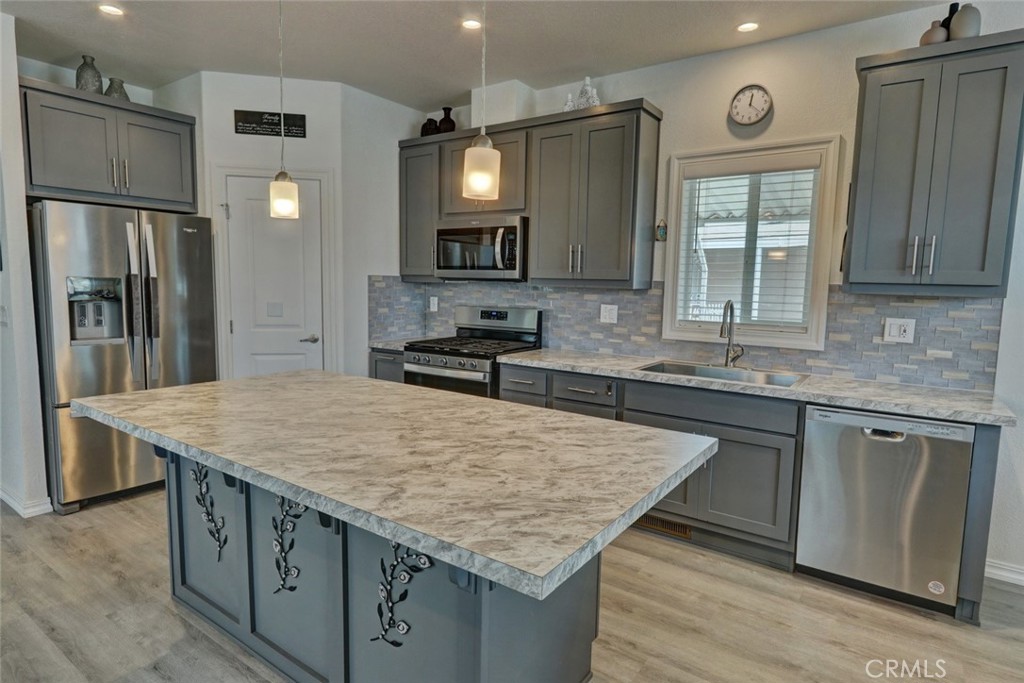 22221 Bloomfield Street, Unit 47 Cypress, CA 90630 - Photo 5 of 30 a kitchen with stainless steel appliances granite countertop wooden cabinets a refrigerator and a sink
