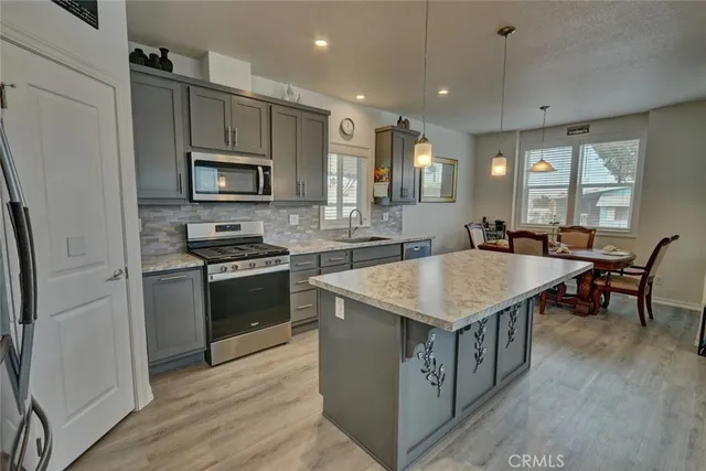 a kitchen with stainless steel appliances granite countertop wooden cabinets a refrigerator and a sink