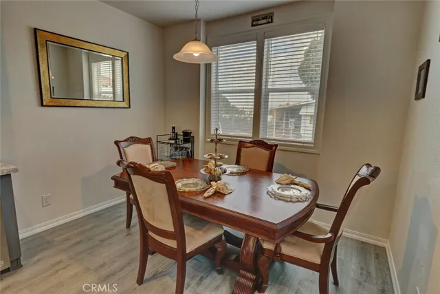 a kitchen with stainless steel appliances granite countertop a kitchen island hardwood floor sink stove dining table and chairs