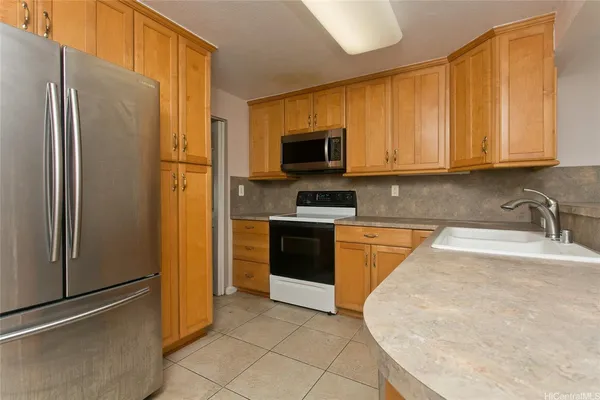 a kitchen with stainless steel appliances granite countertop a refrigerator a stove and a sink
