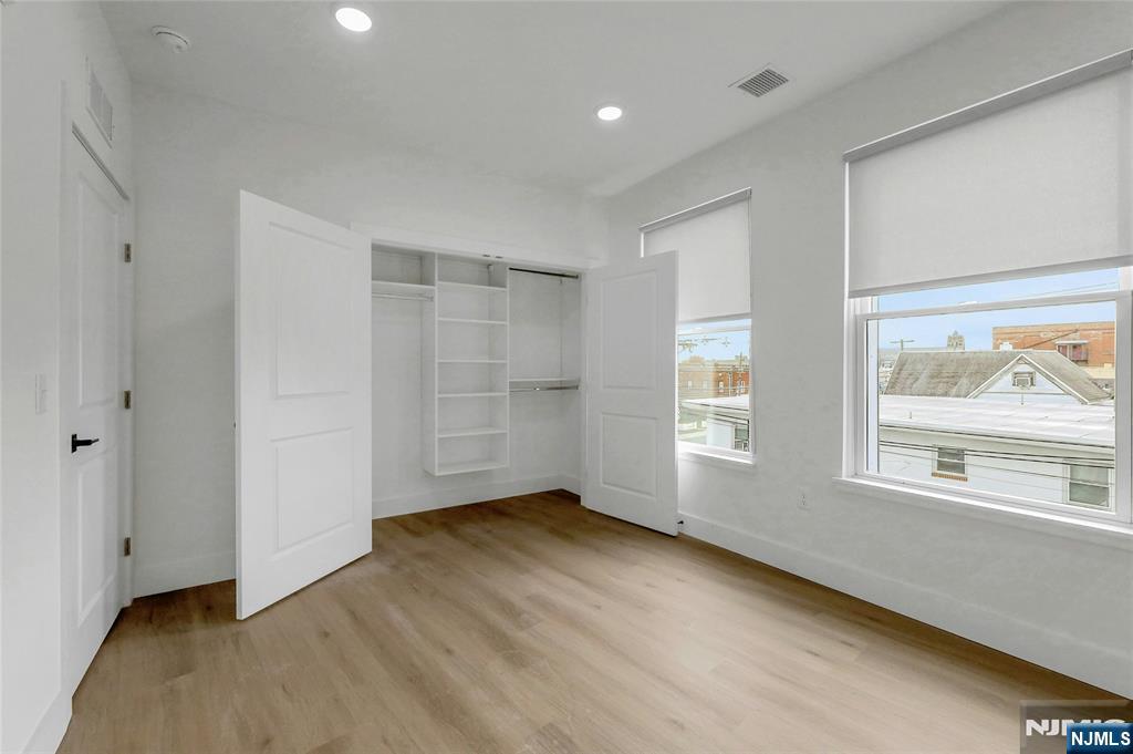 255 Ridge Road, Unit 201 Lyndhurst, NJ 07071 - Photo 18 of 24 a view of an empty room with a window and wooden floor