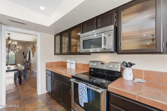 a kitchen with stainless steel appliances granite countertop a stove microwave and sink