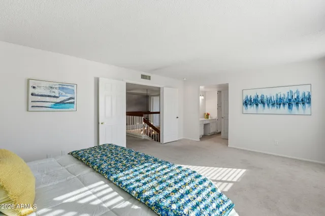 a bedroom with a large bed and a chandelier