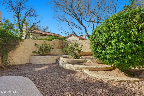 a backyard of a house with table and chairs under an umbrella
